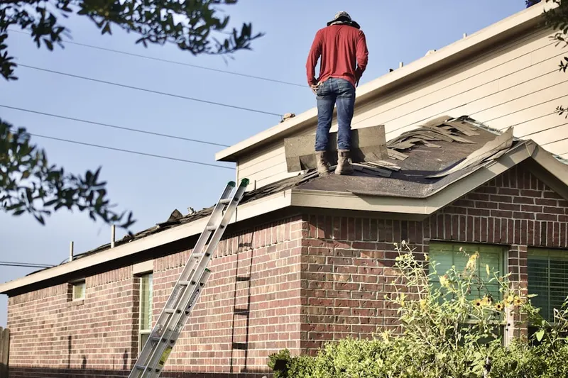 Professional roofer working on a residential roof in Schlichter